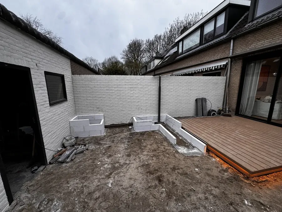 Plantenbakken van witte blokken opgemetseld langs de tuinmuur