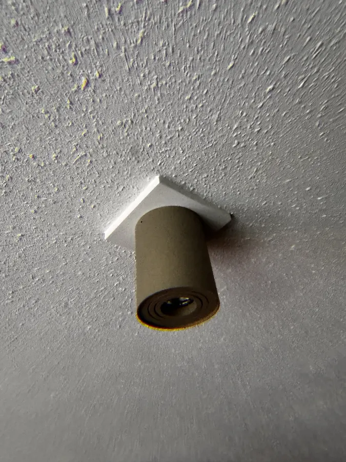 Het resultaat: de nieuwe opbouwspot op de witte afdekplaat, met de naad naar het plafond netjes afgekit
