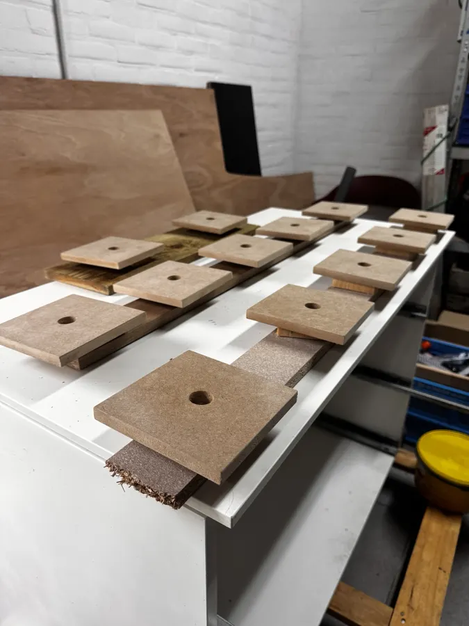 Vierkante afdekplaten van 12 mm mdf, op maat gezaagd en voorgeboord voor de bekabeling